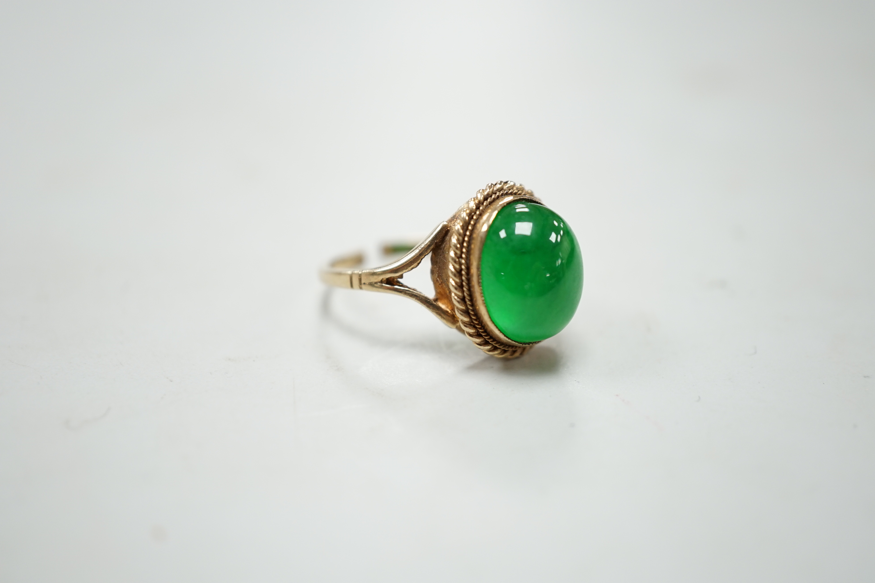 A 9ct gold and cabochon jade set oval ring (shank cut), gross weight 4.3 grams.